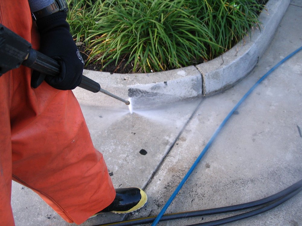 residential power washing service cleaning the curb of a sidewalk in Country Walk, Florida